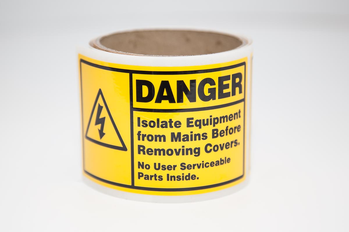 roll of bright yellow danger labels for industrial application