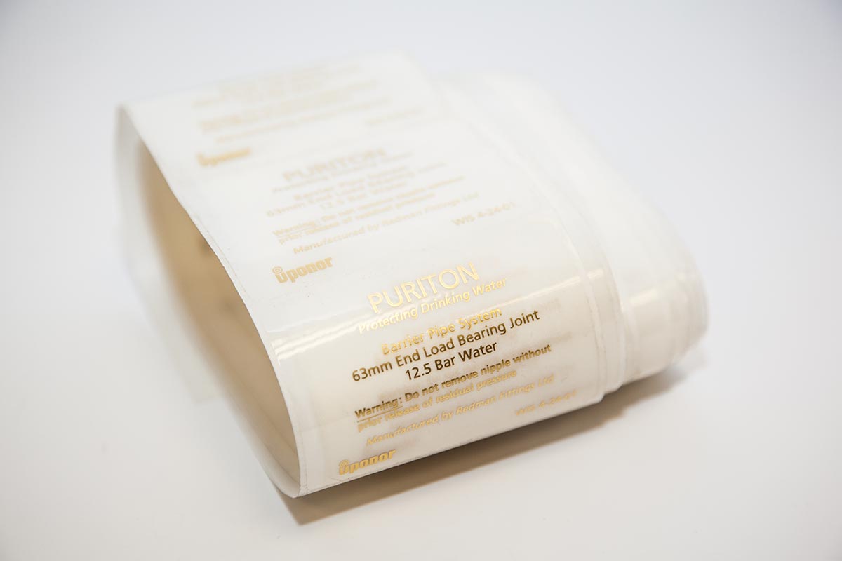loose roll of clear polyester labels with gold printed text